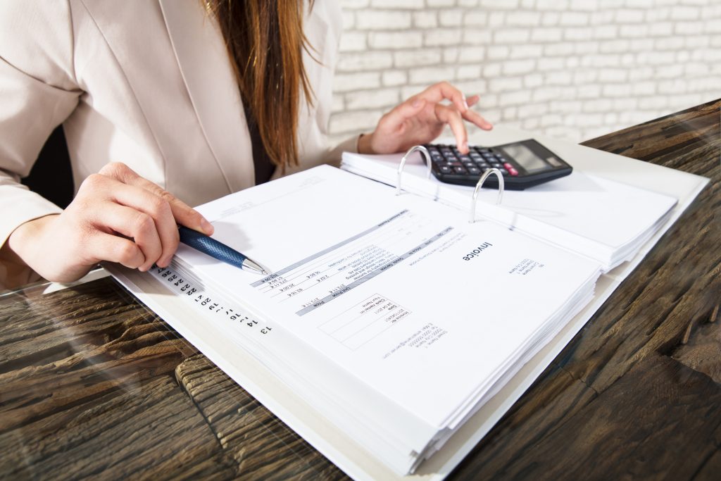 Businesswoman Calculating Invoice